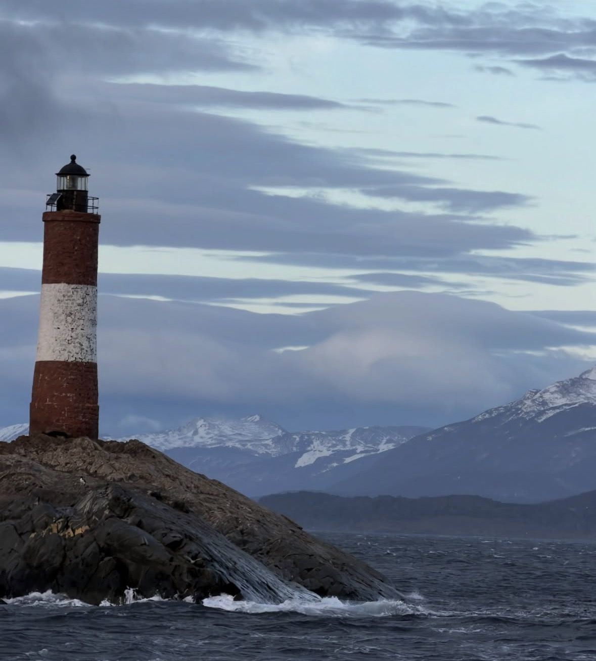 Ushuaia harbour with tour boats moored and snow-capped mountains in the background, gateway to the Beagle Channel